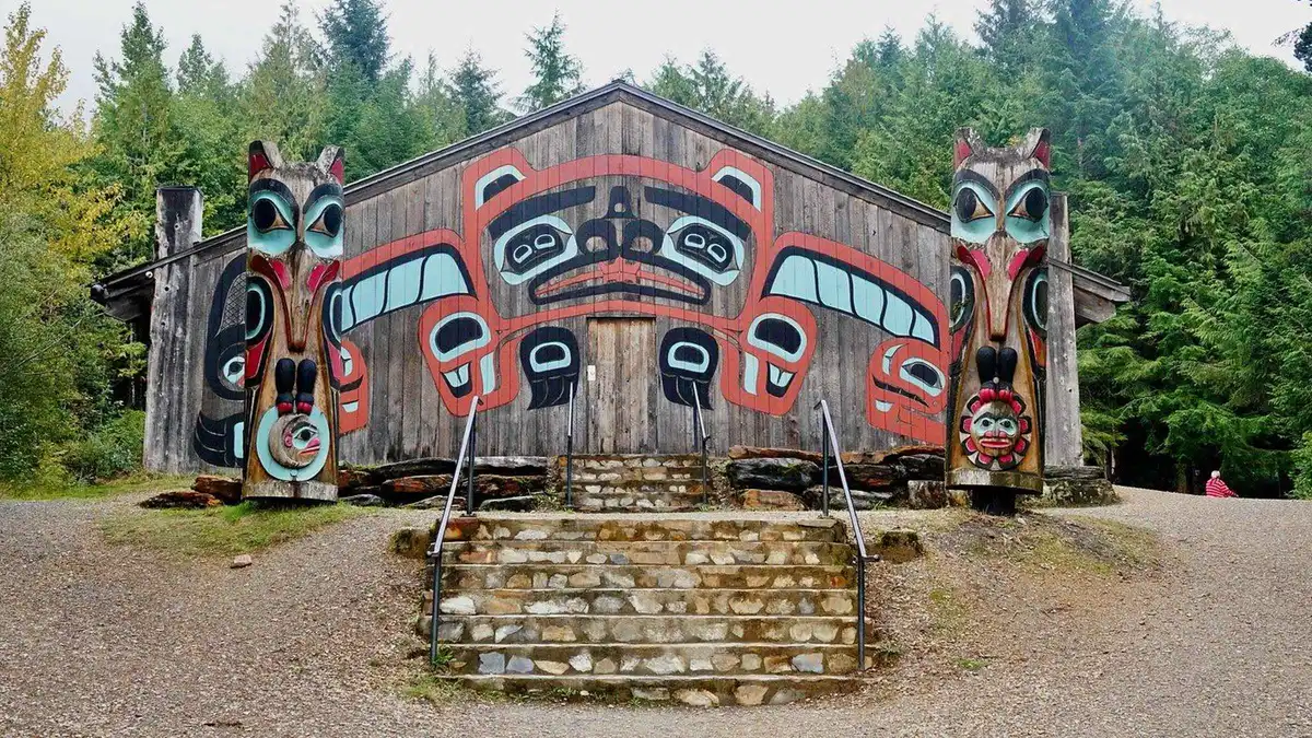 A line of standing totem poles at Saxman Totem Park on a city tour with salmon tasting in Ketchikan, Alaska